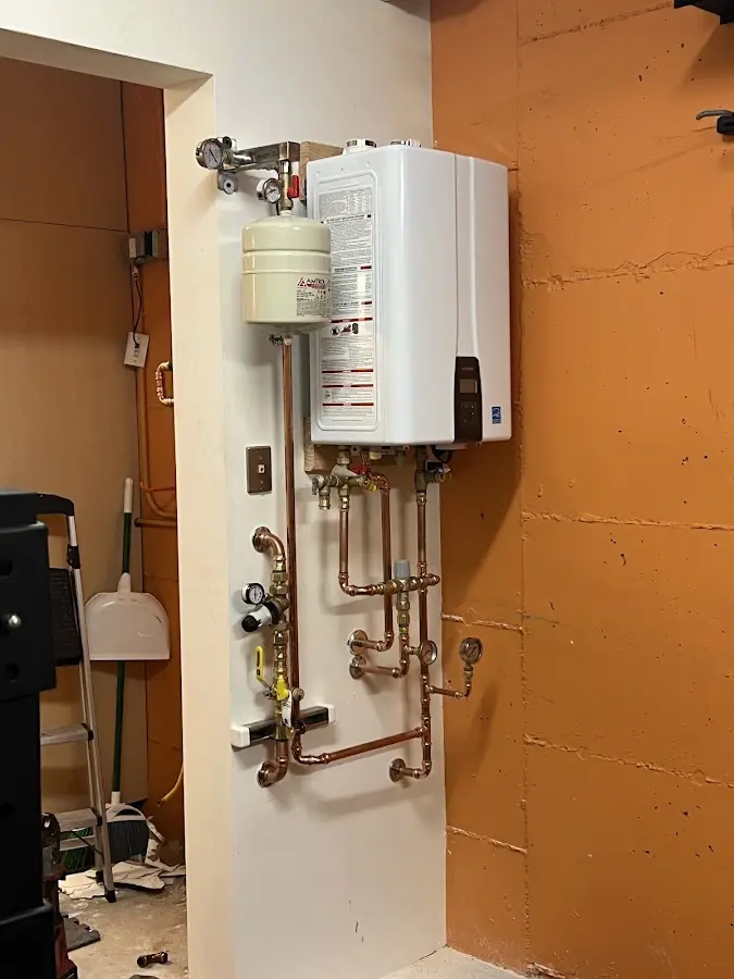 Plumbing technician inspecting water heater connections in North Potomac